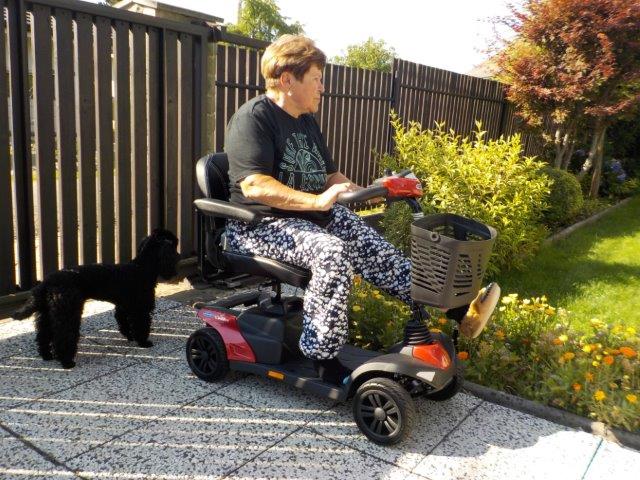 Paní Zrůnková venku se svým asistenčním pudlíkem na novém miniskútru Paní Zrůnková venku se svým asistenčním pudlíkem na novém miniskútru
